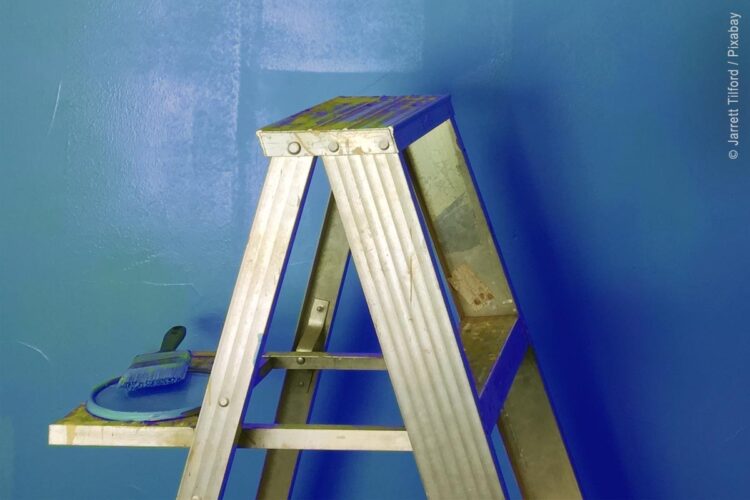 Leiter vor blauer Wandfläche
